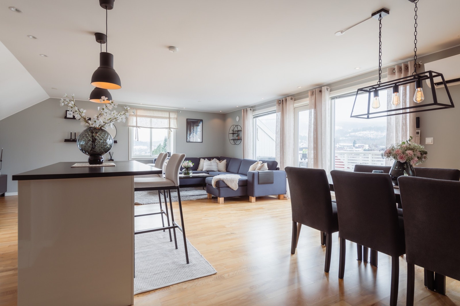 Stue og kjøkken i åpen løsning med godt naturlig lys, og en kjøkkenøy med sitteplasser binder rommet fint sammen. Galleribilde