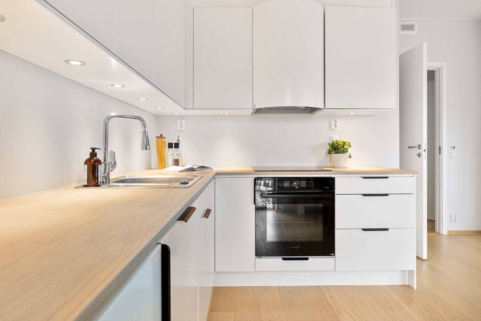 Lekkert kjøkken med glatte fronter, laminert benkeplate med dobbel oppvaskkum med svingbart blandebatteri. Det er integrert kjøl/fryseskap, oppvaskmaskin, stekeovn og platetopp med mekanisk avtrekksvifte over stekesonen. Galleribilde