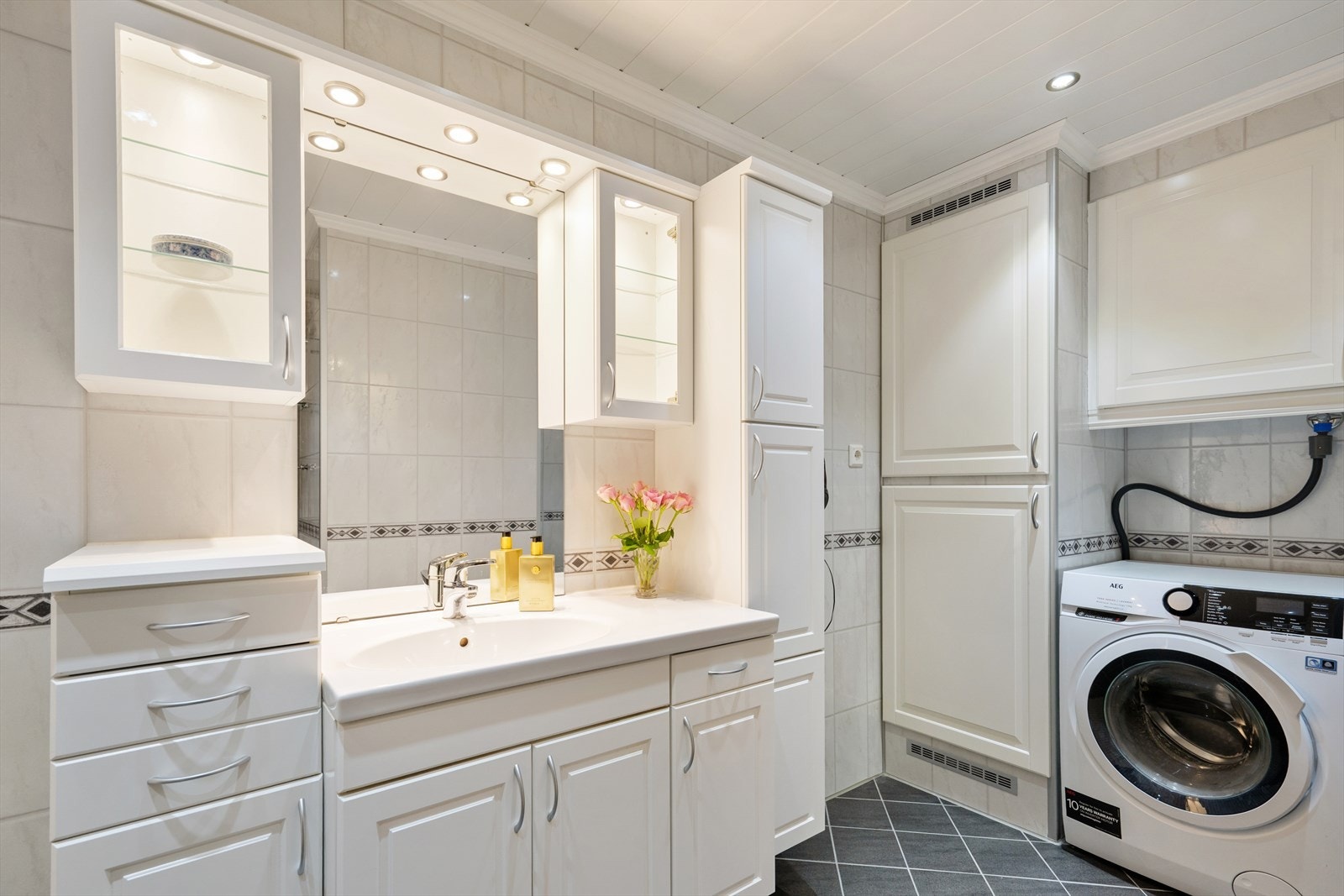 Badet har innredning med nedfelt servant, dusjkabinett og opplegg for vaskemaskin Galleribilde