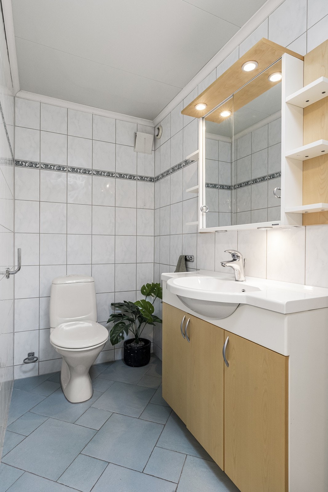 Praktisk toalettrom i underetasjen med flislagte vegger og gulv. Galleribilde