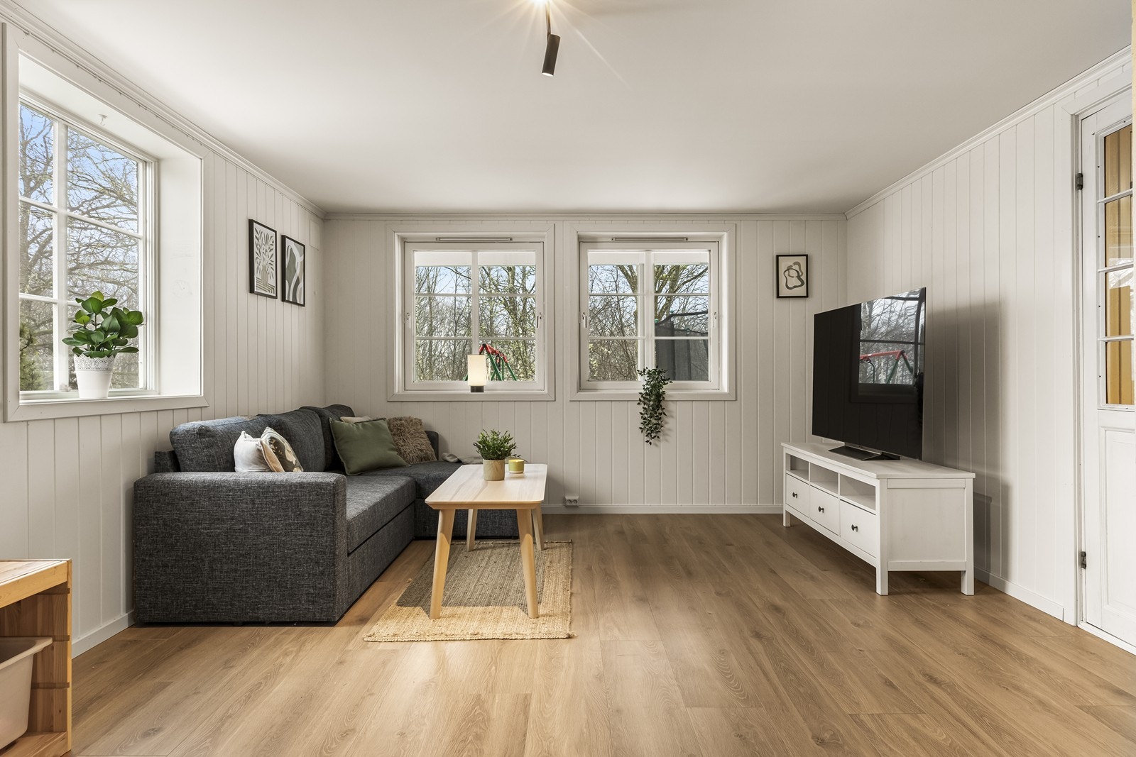 Stuen i underetasjen har laminatgulv og vegger med trepanel. Galleribilde