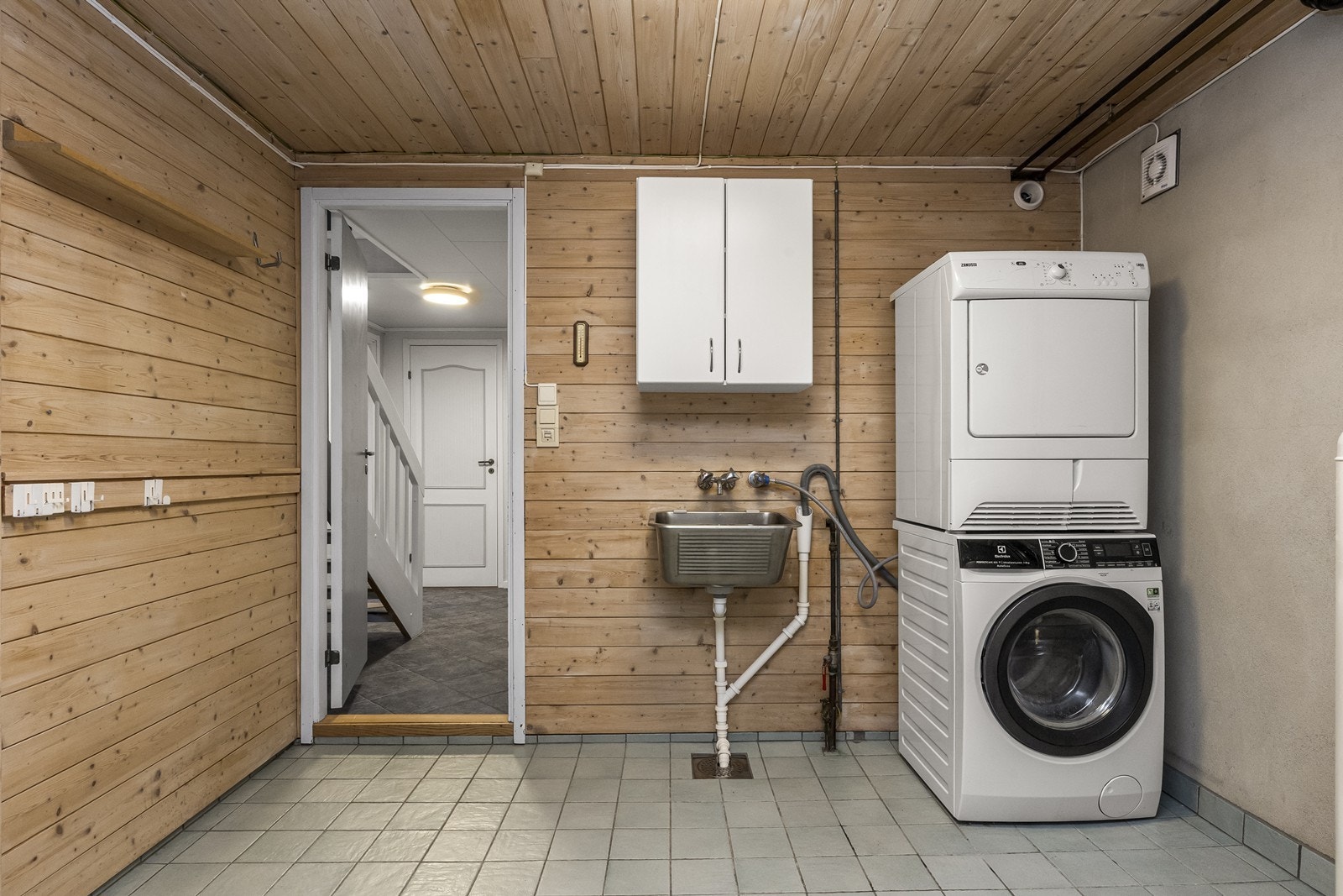 Separat vaskerom med flislagt gulv, gulvvarme og opplegg for vaskemaskin. Galleribilde