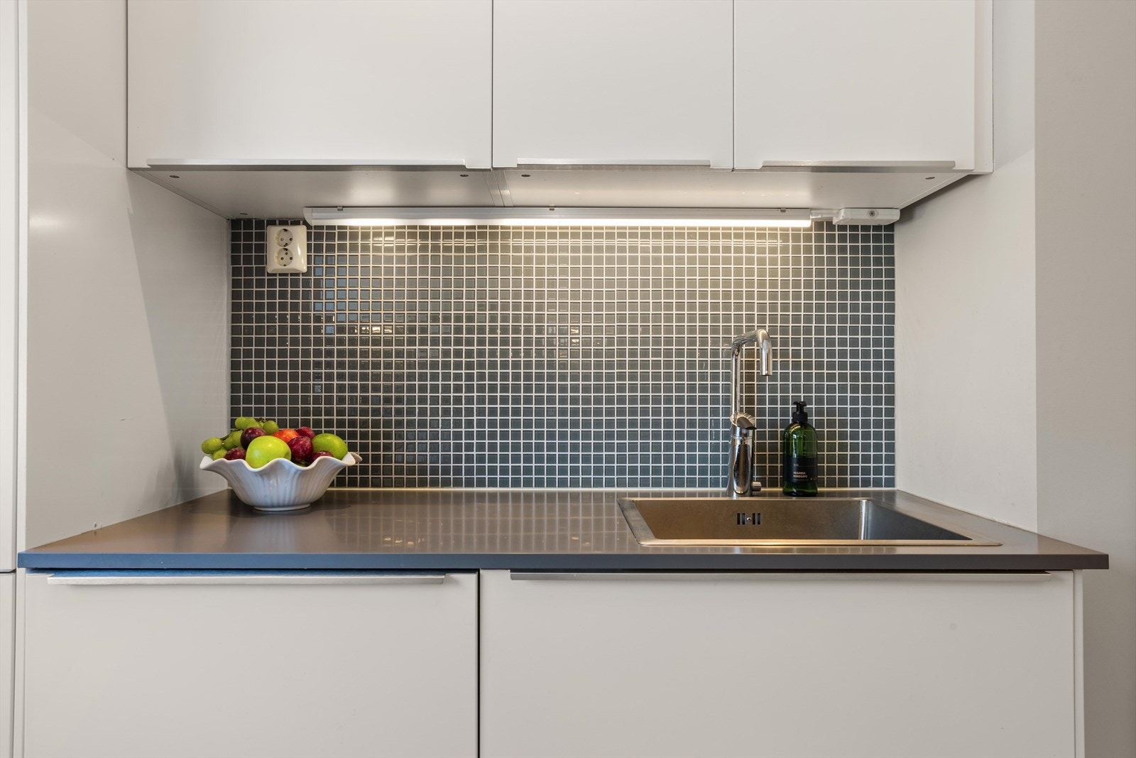 Det er belysning mellom over-/underskapene som gir lys til benkeplatene. I tillegg sørger integrerte downlights i himlingen for stemningslys og ekstra godt arbeidslys. Galleribilde