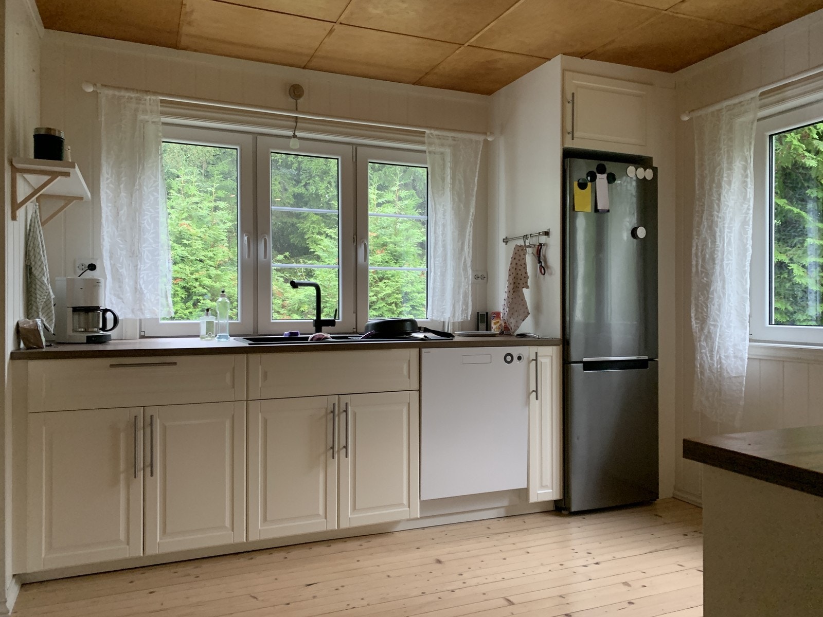 Pent kjøkken med oppvaskmaskin, komfyr, steketopp og kombiskap. Galleribilde