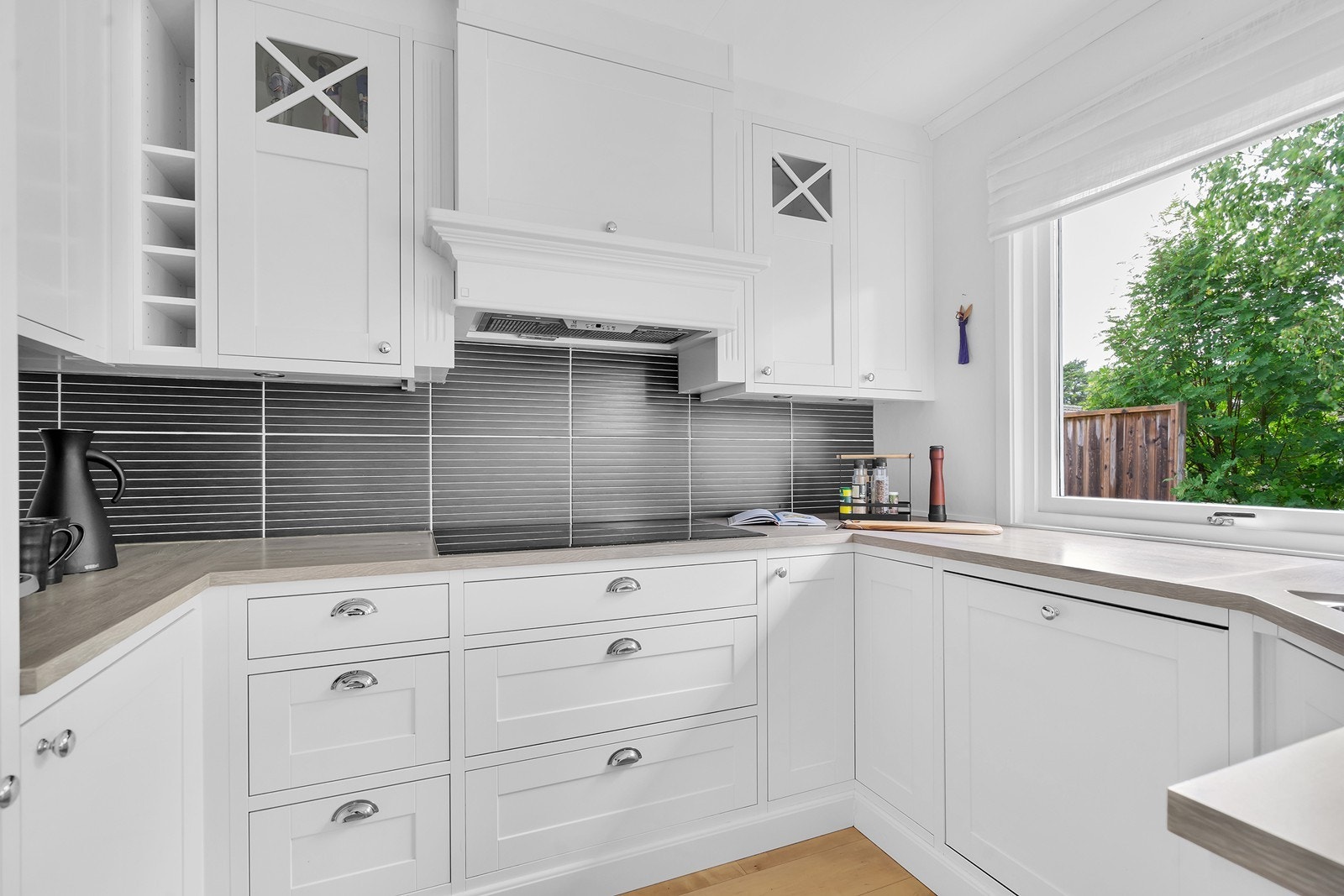 Hvit profilert innredning med intergrerte hvitevarer, bla. fra Siemens. Induksjonstopp(90 cm med 5 soner), oppvaskmaskin, kjøleskap stekeovn, kombiovn (stekeovn + mikro) Galleribilde