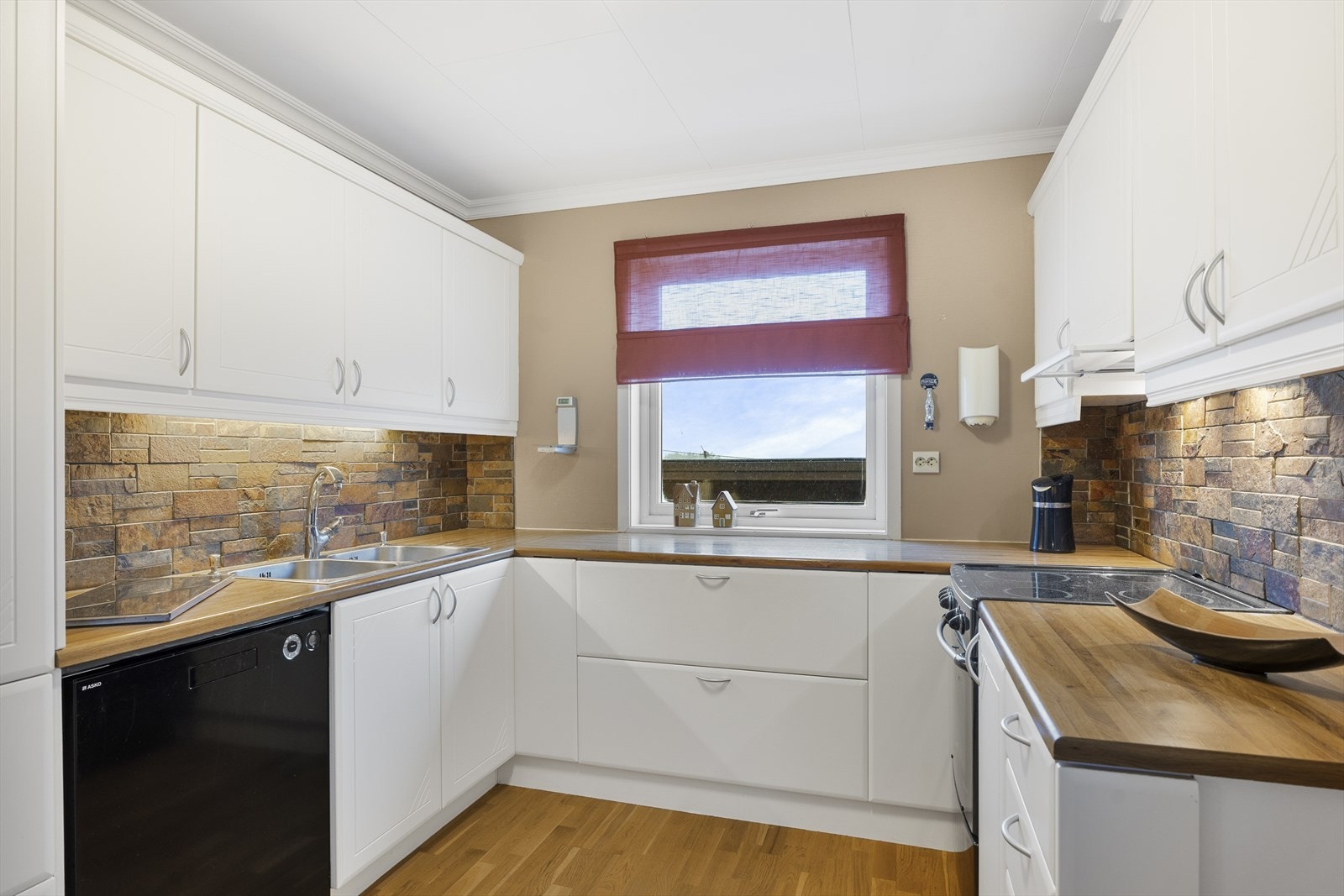 Kjøkkenet har innredning med både profilerte og slette fronter samt laminat benkeplate - det ble montert ny kjøkkenventilator i 2026 Galleribilde