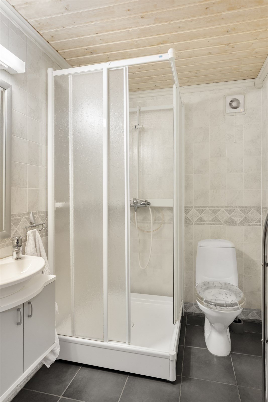 Badet i underetasjen har vinylbelegg på veggene, fliser på gulvet og panel i himlingen (ikke omsøkt/godkjent) Galleribilde