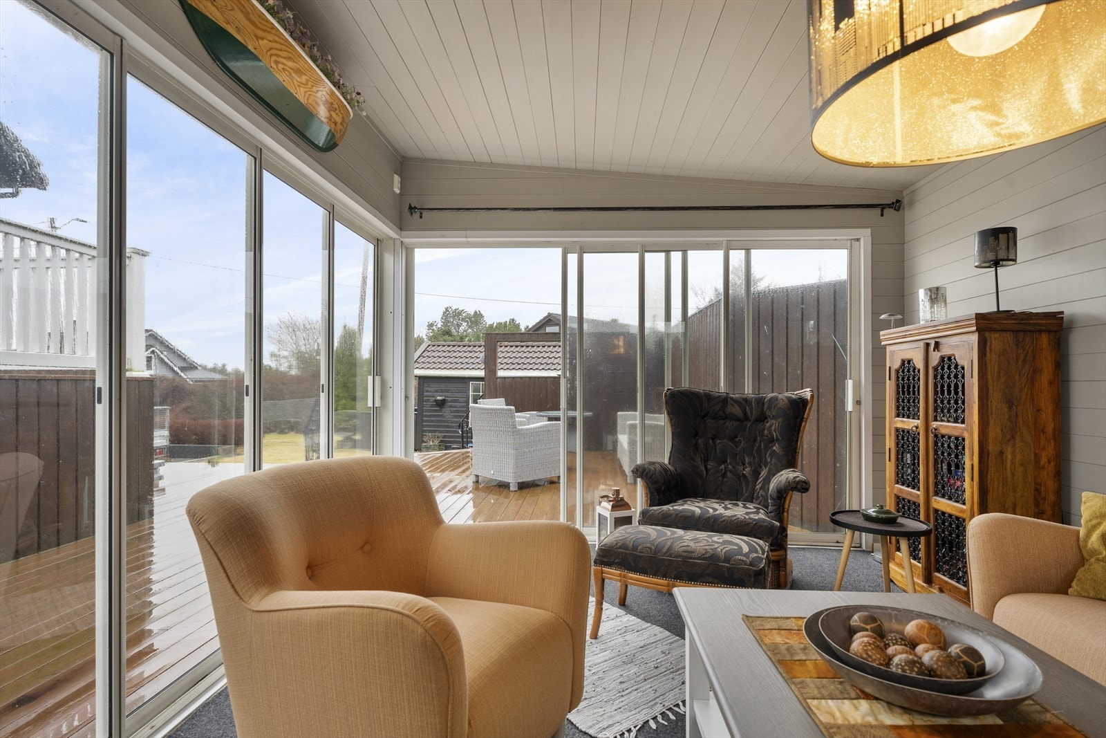 Den koselige hagestuen har teppe på gulv samt malt panel på vegger og i himling Galleribilde