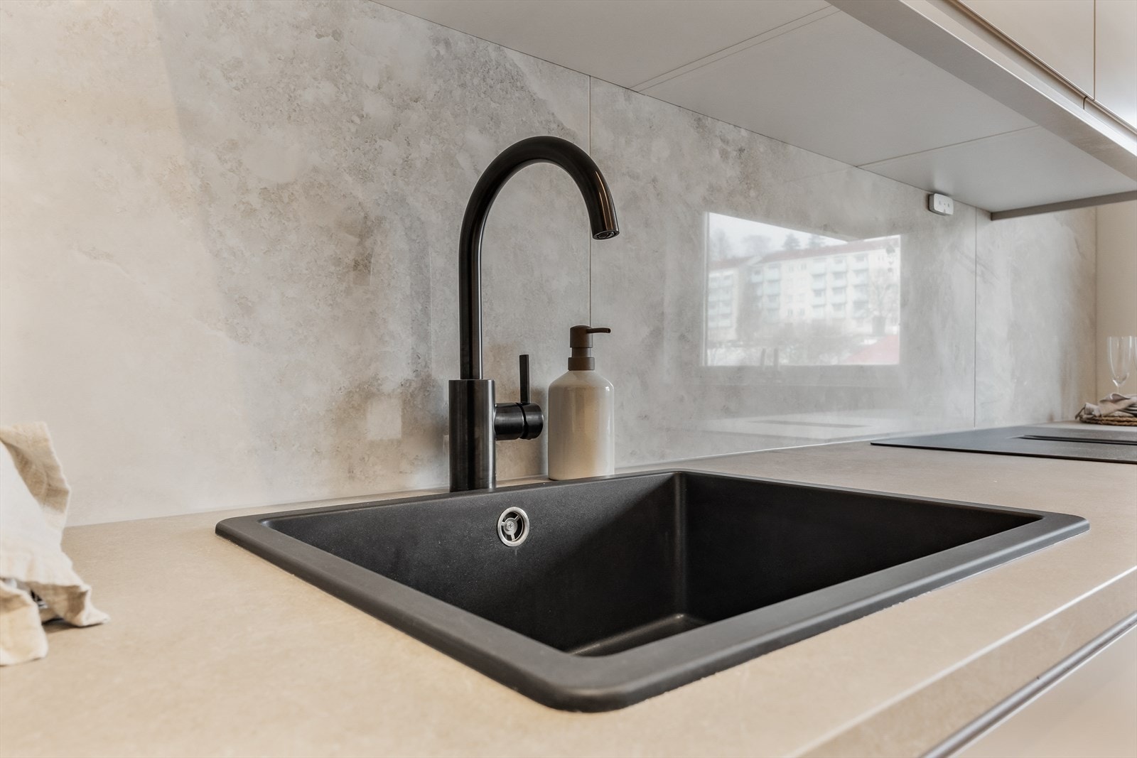 Sort blandebatteri og underlimt vask komplementerer den moderne stilen. Galleribilde