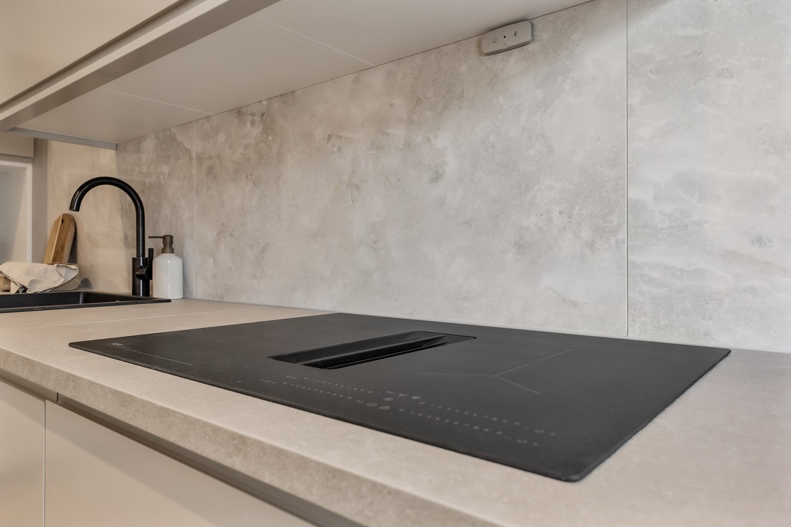 Moderne induksjonstopp med integrert ventilator gir en ren og effektiv arbeidsflate. Galleribilde