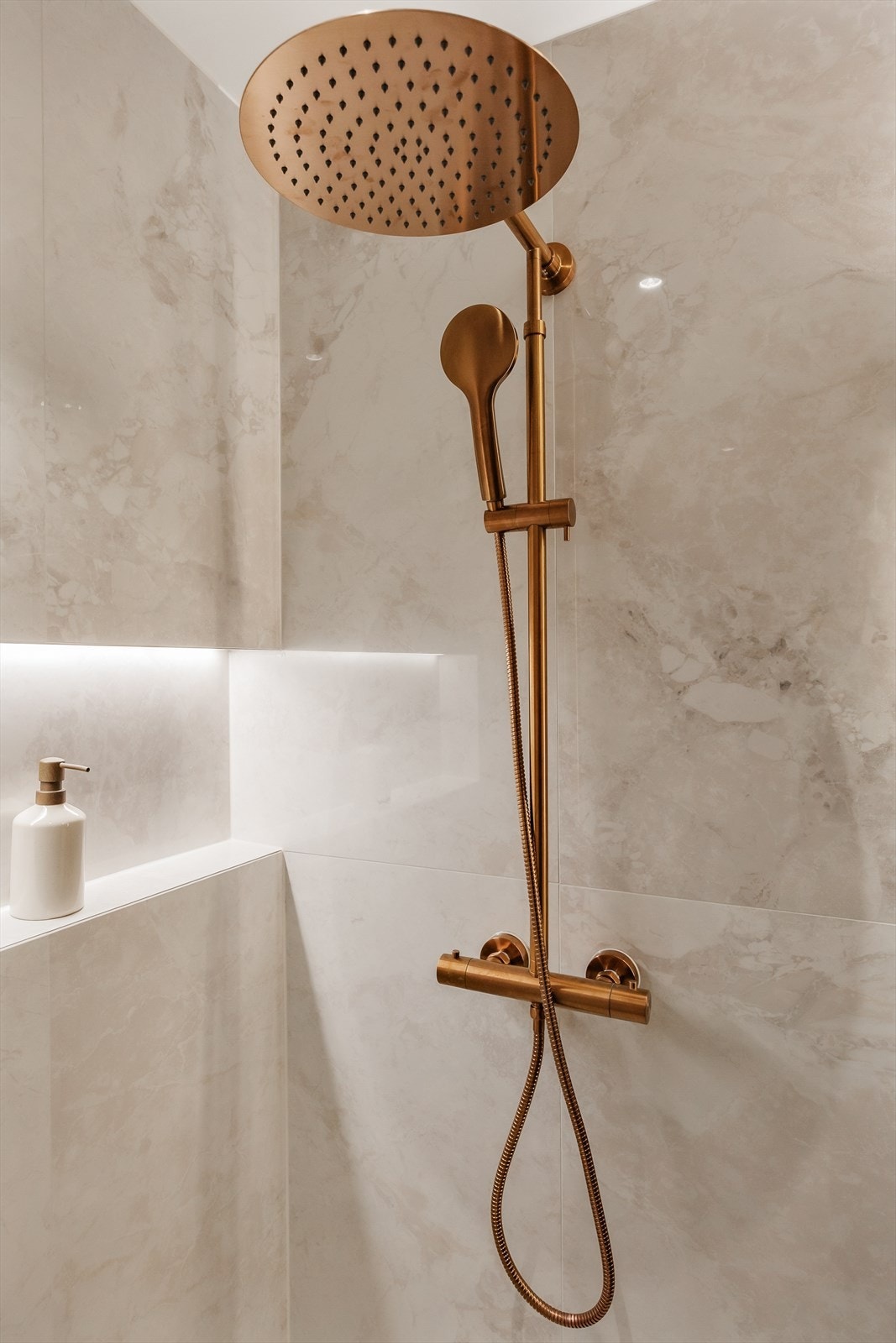 Detaljer som armatur i børstet messing gir badet et luksuriøst uttrykk. Galleribilde