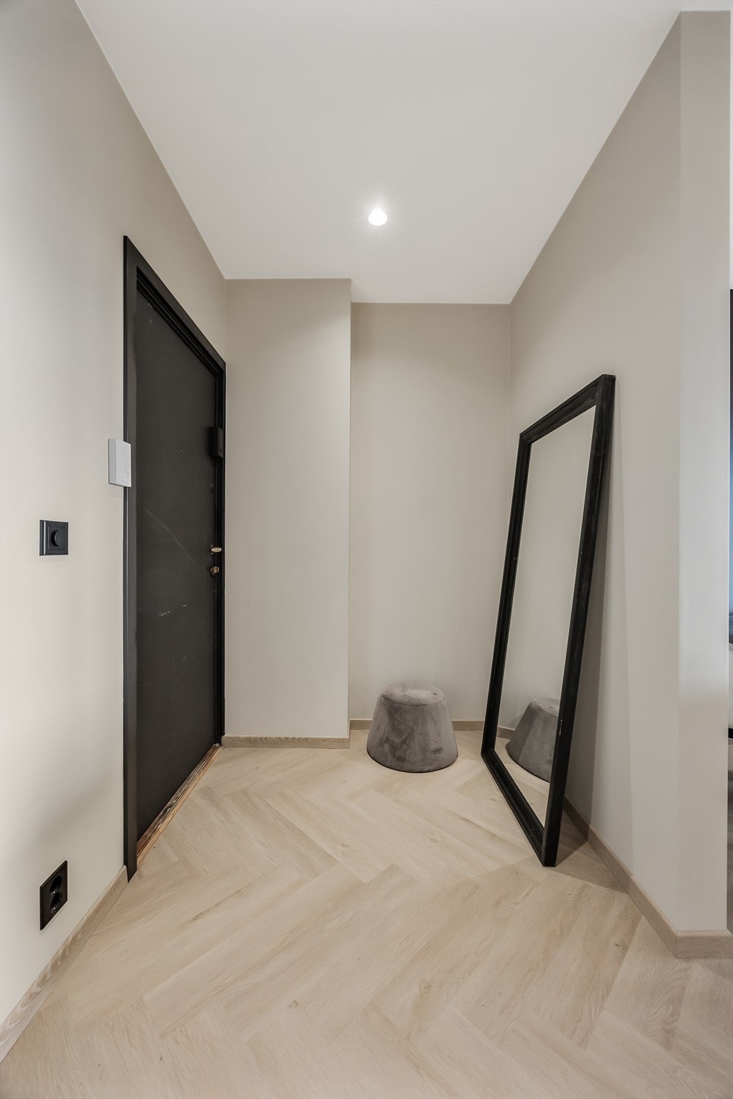 Gjennomgående fiskebensmønster og mørke detaljer skaper en helhetlig og moderne stil. Galleribilde