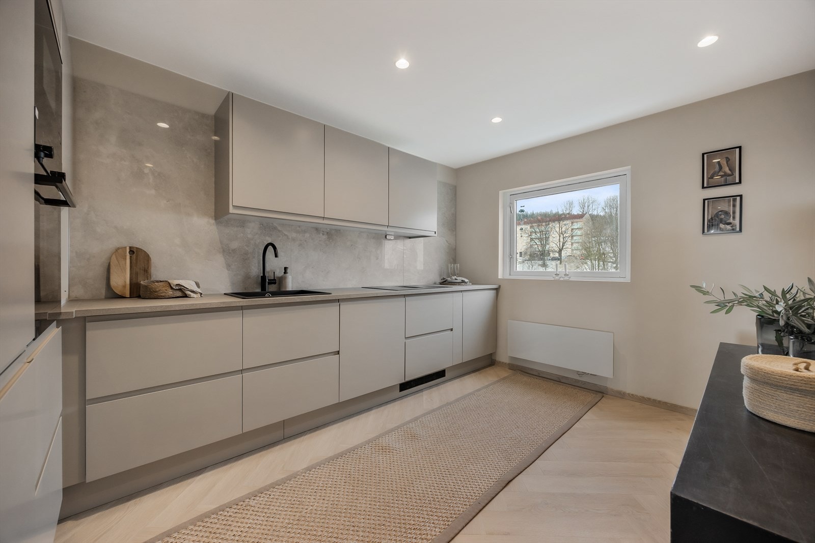 Leiligheten har et stilrent kjøkken med glatte fronter og integrerte hvitevarer. Galleribilde