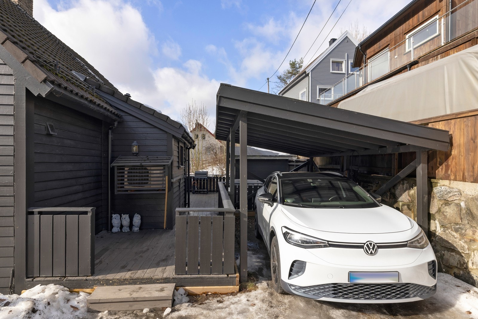 Tilhørende carport og terrasse ved inngangsparti. Installert elbil lader i fra Zaptec Galleribilde