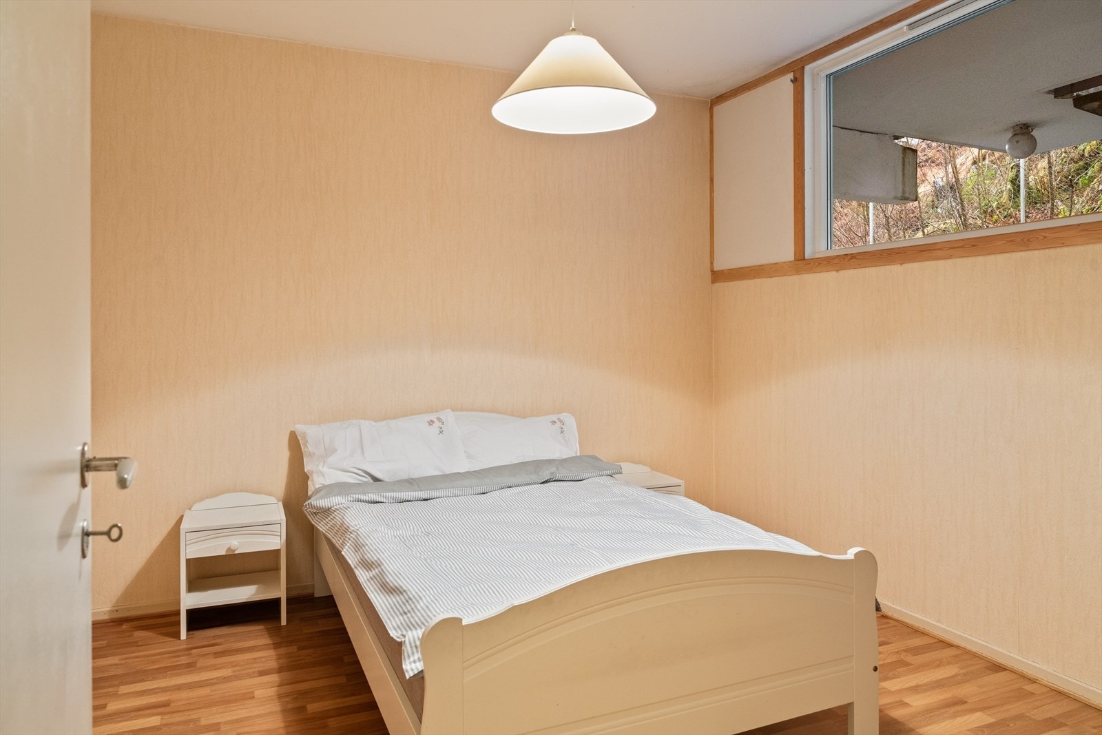 Stort og lyst soverom med vindu vendt vekk fra veien Galleribilde