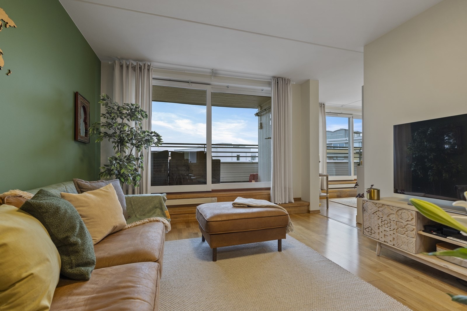 Store vindusflater strekker seg fra stuen til spisestuen og videre inn til kjøkkenet, noe som gir godt med naturlig lys i hele romsonen. Galleribilde