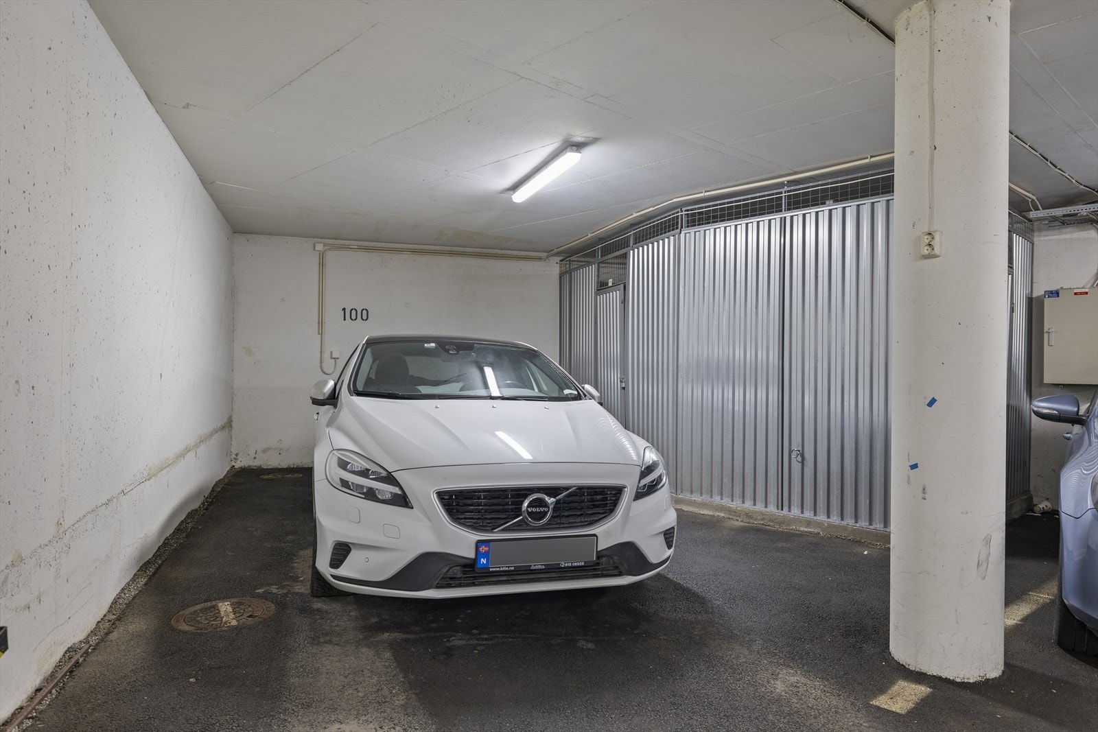 Med leiligheten følger en parkeringsplass som muligens er sameiets beste (avbildet). Her står bilen uten parkeringsplasser tett inntil på sidene. Boden nr. 1 (5 kvm) til høyre for bilen følger boligen. Galleribilde