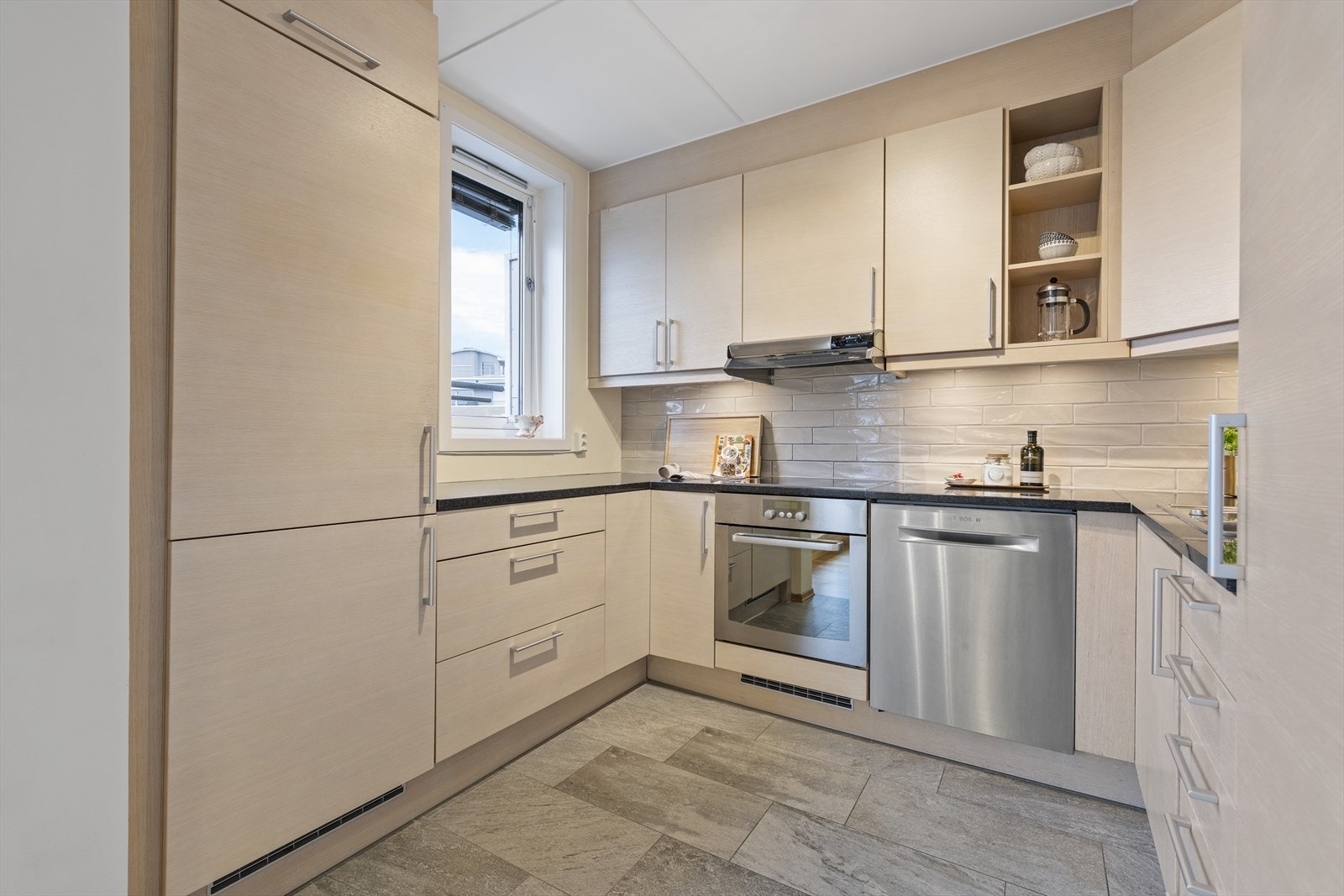 Et stort og moderne kjøkken med rikelig med skapplass og fin utsikt fra arbeidsområdet. Galleribilde