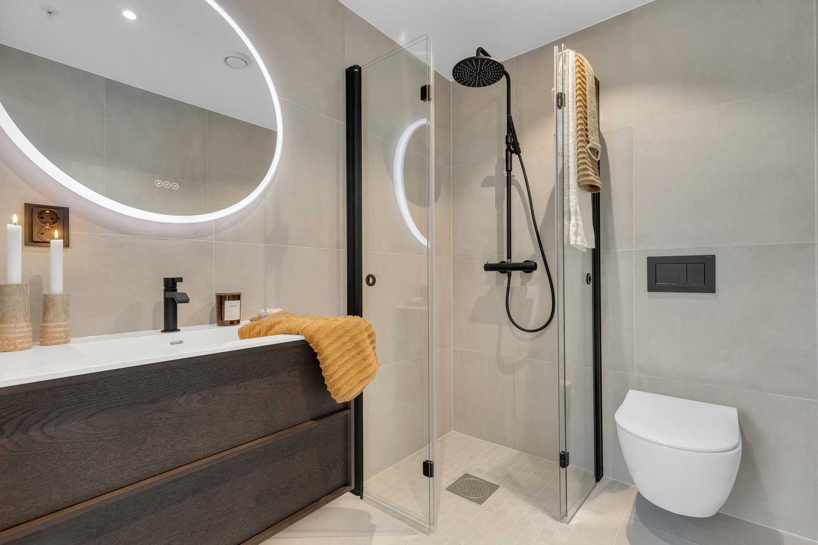 Helstøpt corianvask, speil med integrert belysning, sorte gjennomgående detaljer, nydelige 60x60 fliser og baderomsinnredning fra Korsbakken. Galleribilde