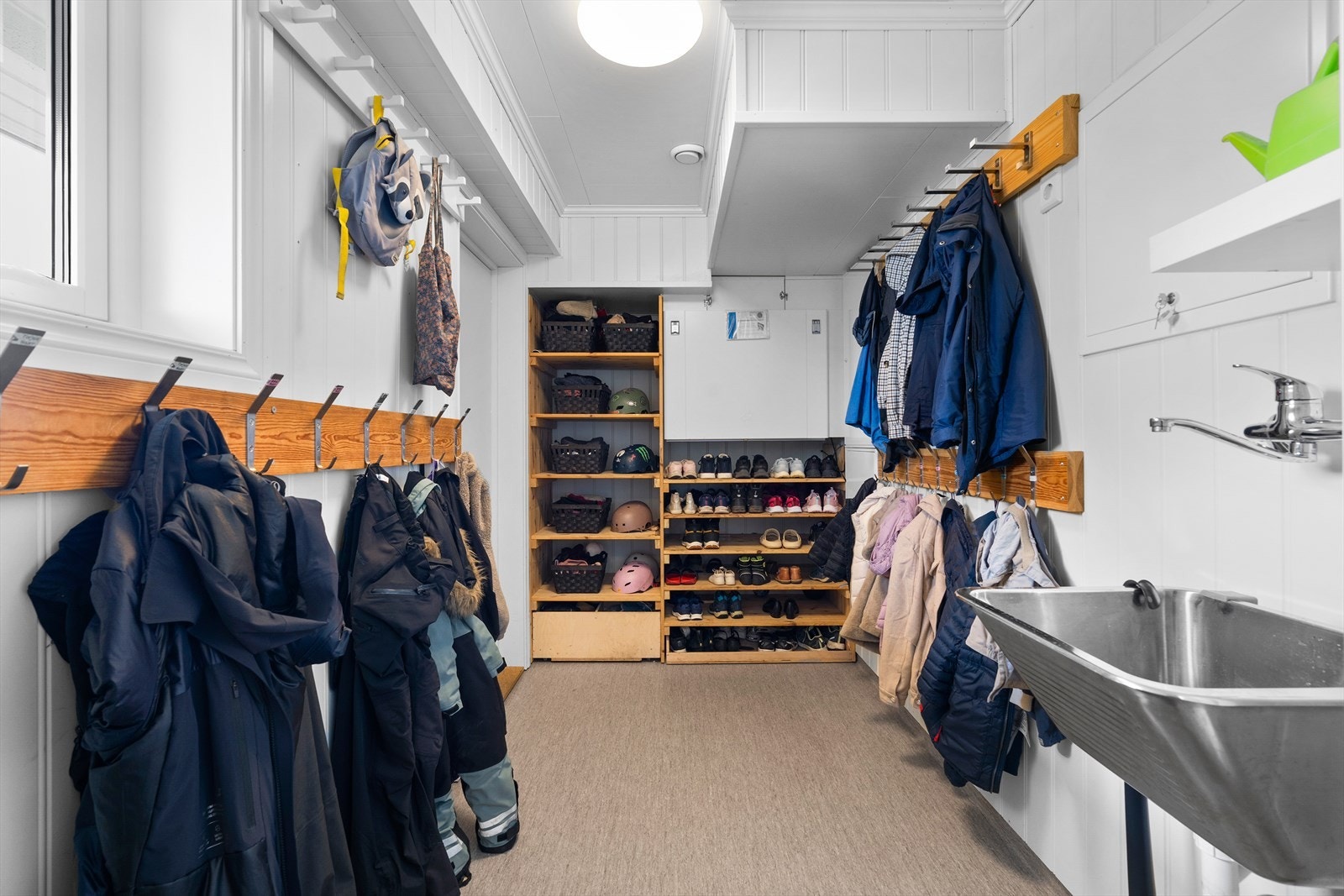 Praktisk bi-inngang med utslagsvask. Legg merke til de stedbygde skohyllene. Galleribilde