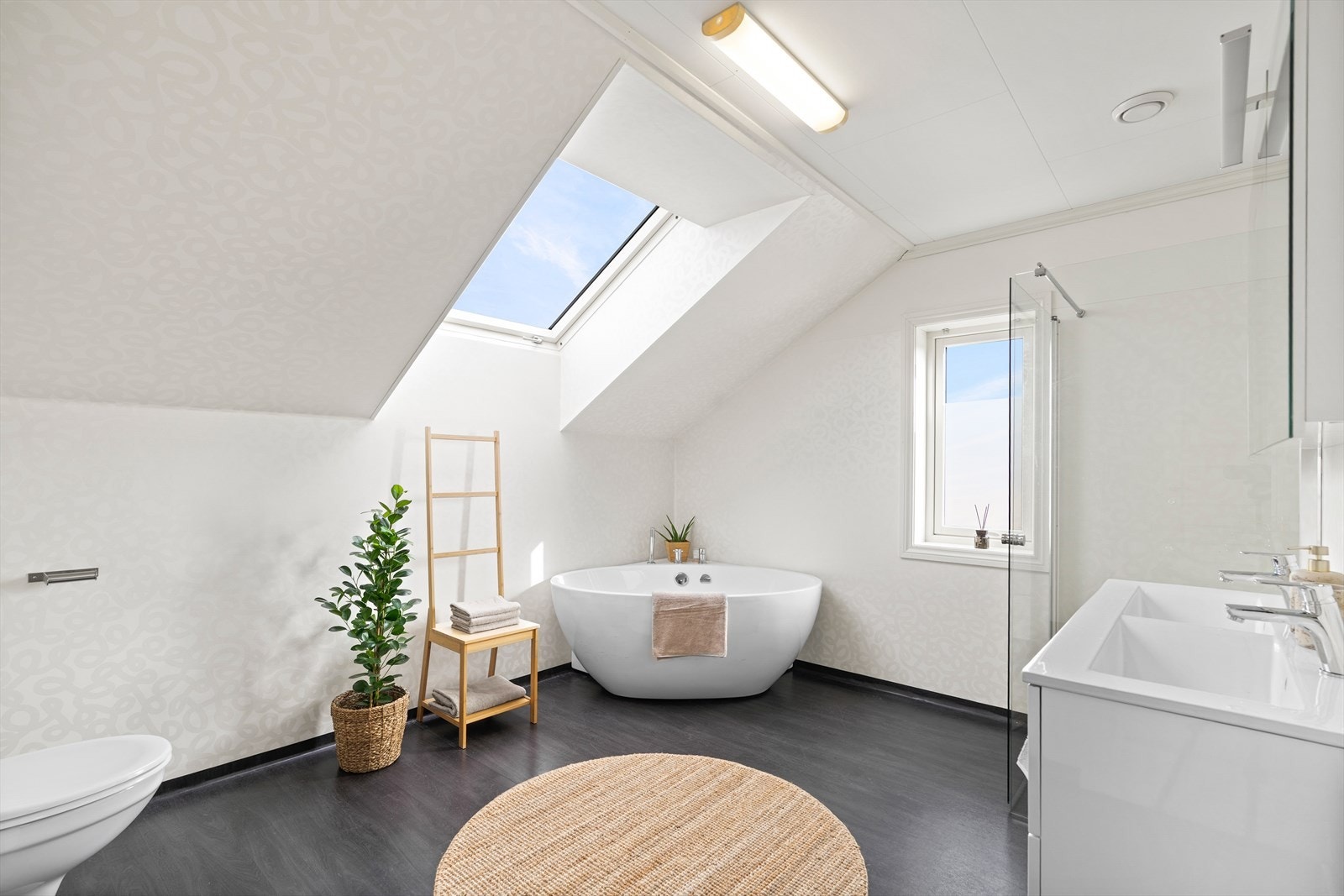 Stort bad, legg merke til de gode lysforholdene. Her er det både badekar, dusj, toalett og servant med skuffeinnredning. Galleribilde