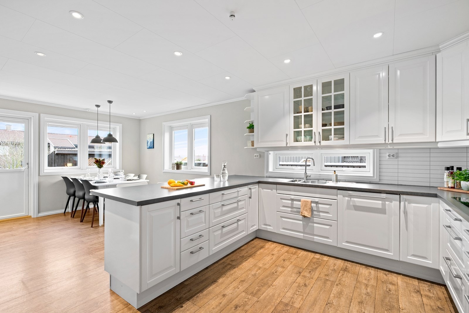 Kjøkkenet har god grunnbelysning med spotter i tak, og takpendler over spisebord. Galleribilde