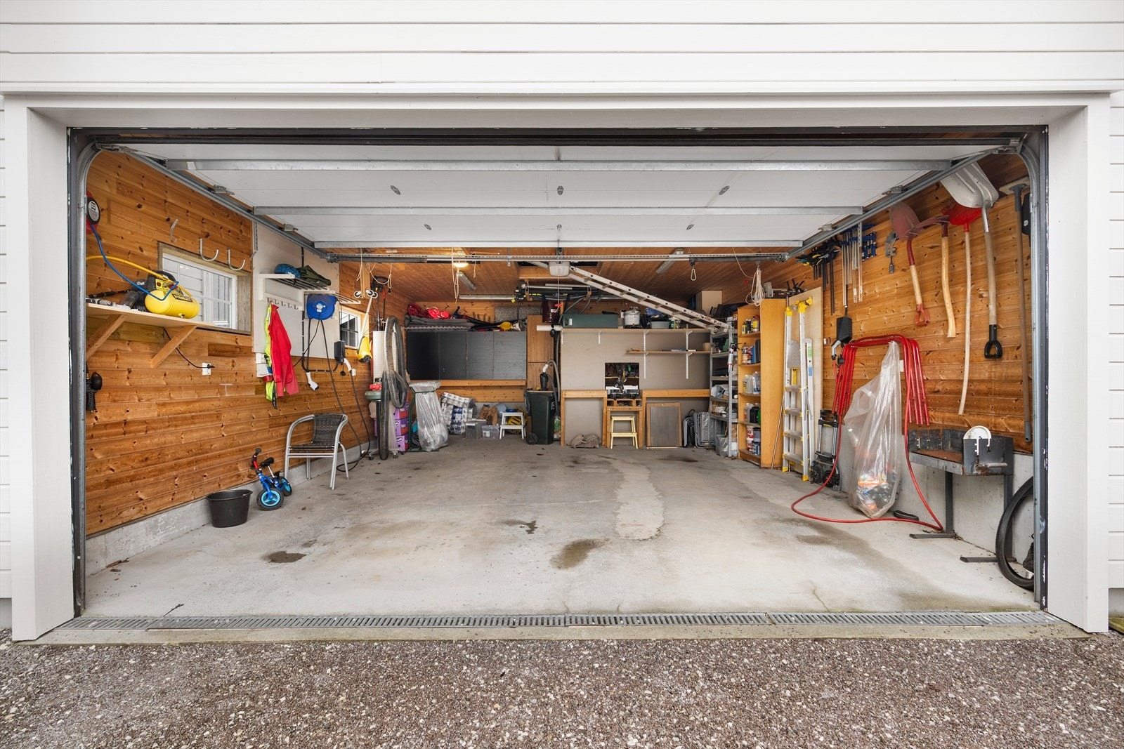 Dobbel garasje med flere smarte løsninger:
- Løpekatt og vinsj for å heise dekk og andre ting opp på loftet.
- Elbillader (pr i dag to ladere, men den ene blir fjernet før overtagelse).
- Vegghengt skap med god oppbevaring.
- Arbeidsbenk. Galleribilde