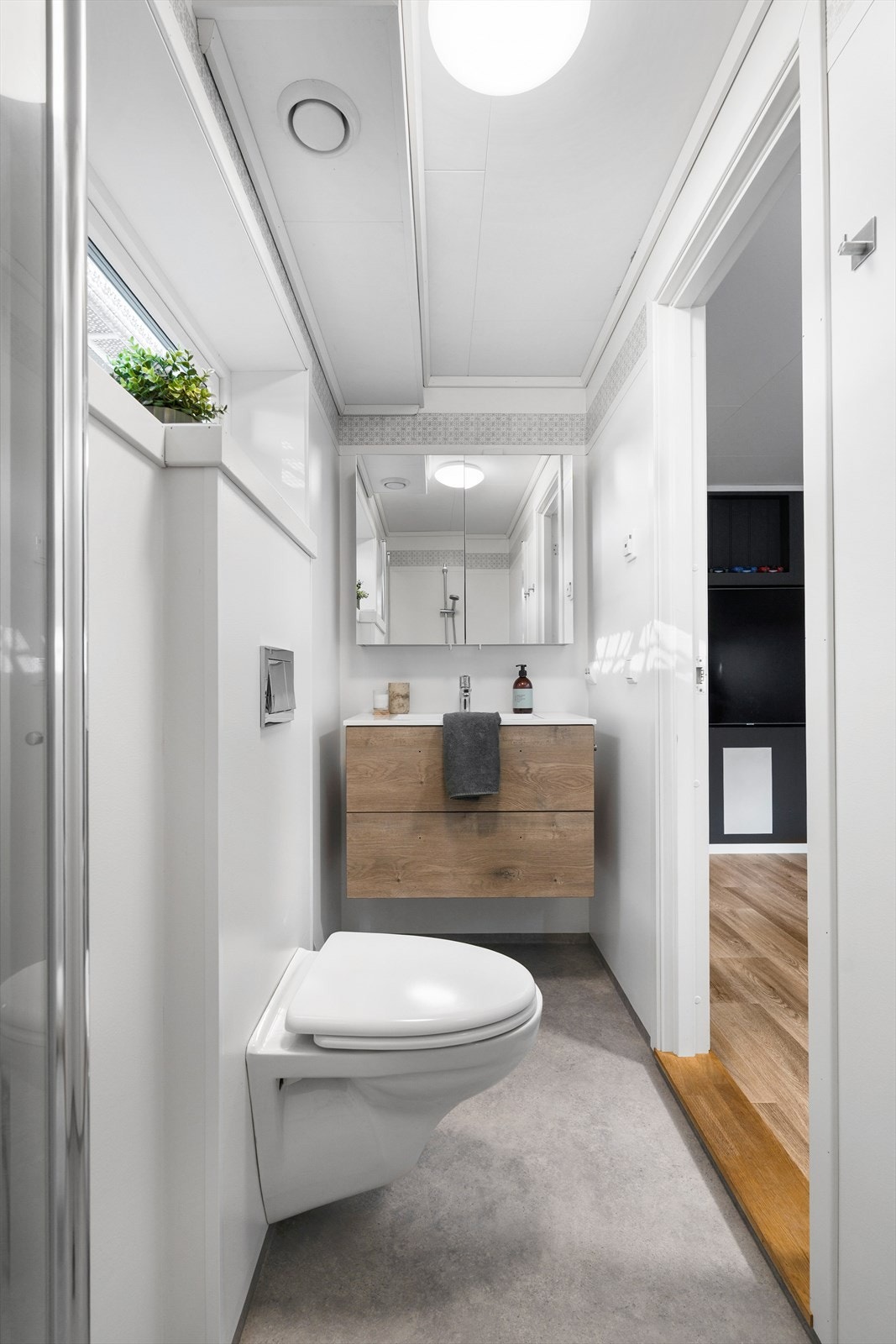 Bad i kjelleretasjen. Badet er lite, men funksjonelt. Her er det dusj, toalett og servant med skuffeinnredning Galleribilde