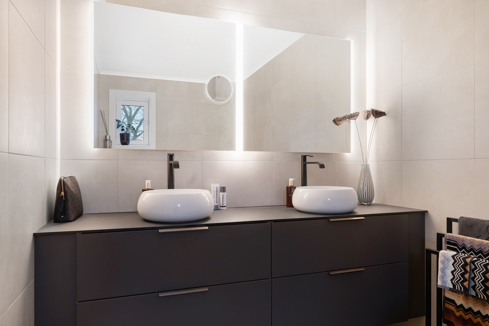 Elegant speil med lys, moderne innredning og dobbel servant som skaper en luksuriøs følelse på badet Galleribilde
