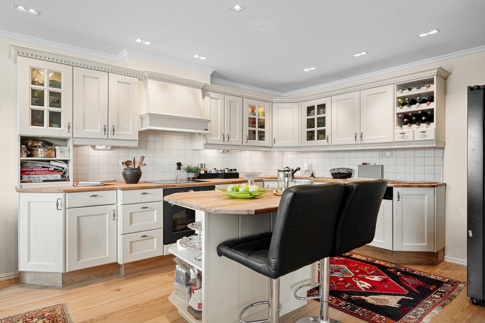 Pent og tidløst kjøkken med praktisk kjøkkenøy for barløsning og matlaging. Galleribilde