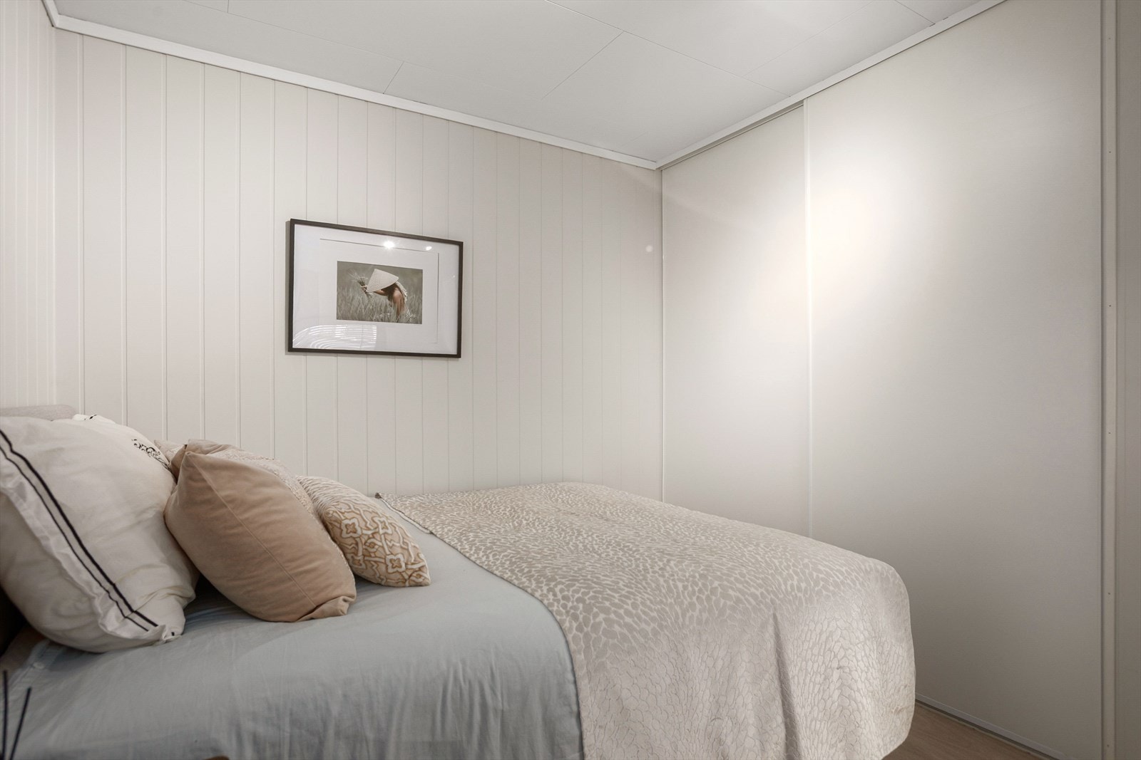 En stor, integrert skyvedørsgarderobe langs veggen gir rikelig med oppbevaringsmuligheter og bidrar til et ryddig og praktisk rom. Galleribilde
