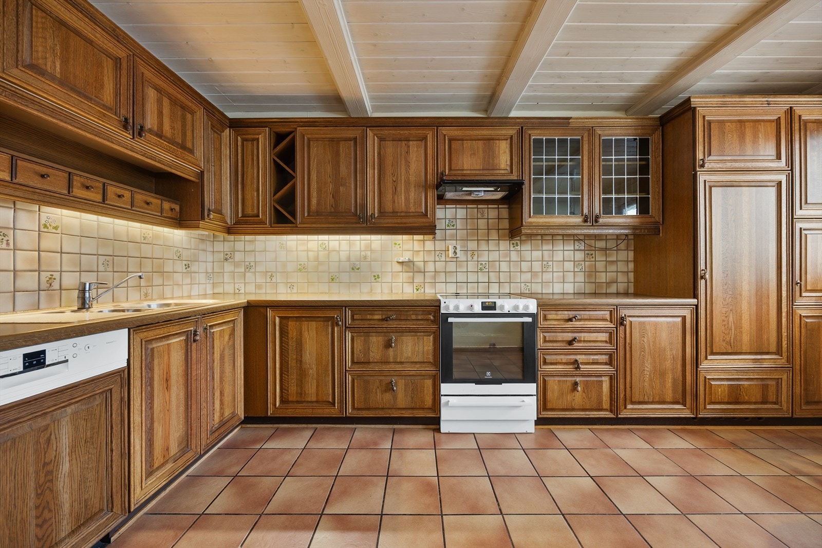 Kjøkkeninnredningen har profilerte eikefronter, vitrineskap og laminat benkeplate. Galleribilde