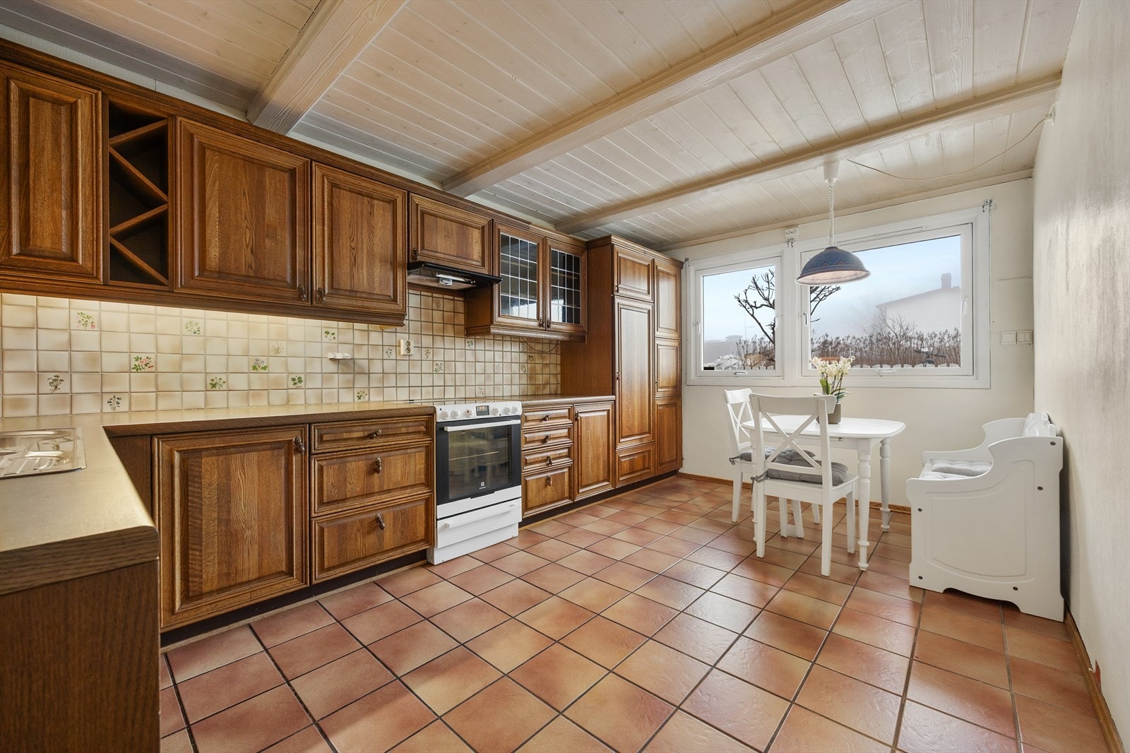 Romslig kjøkken med god skapplass og en hyggelig spiseplass ved vinduet. Galleribilde