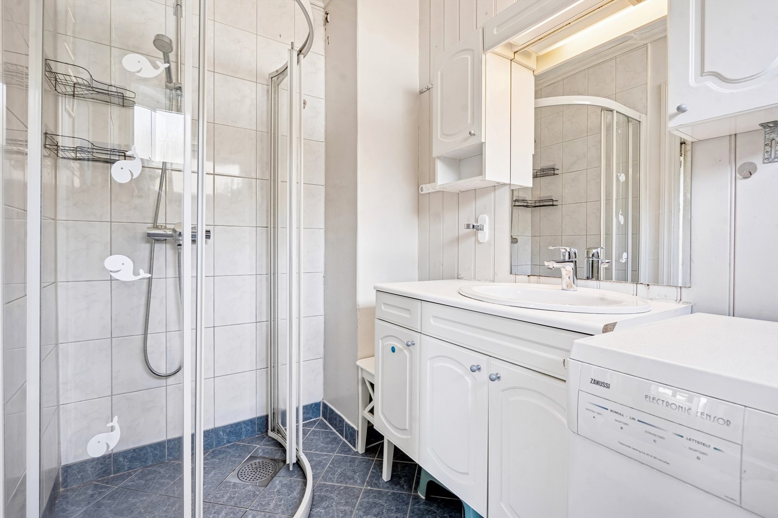 Badet ble oppgardert i 2002 og er innredet med dusjhjørne, servant med skap og speil, wc og opplegg for vaskemaskin Galleribilde