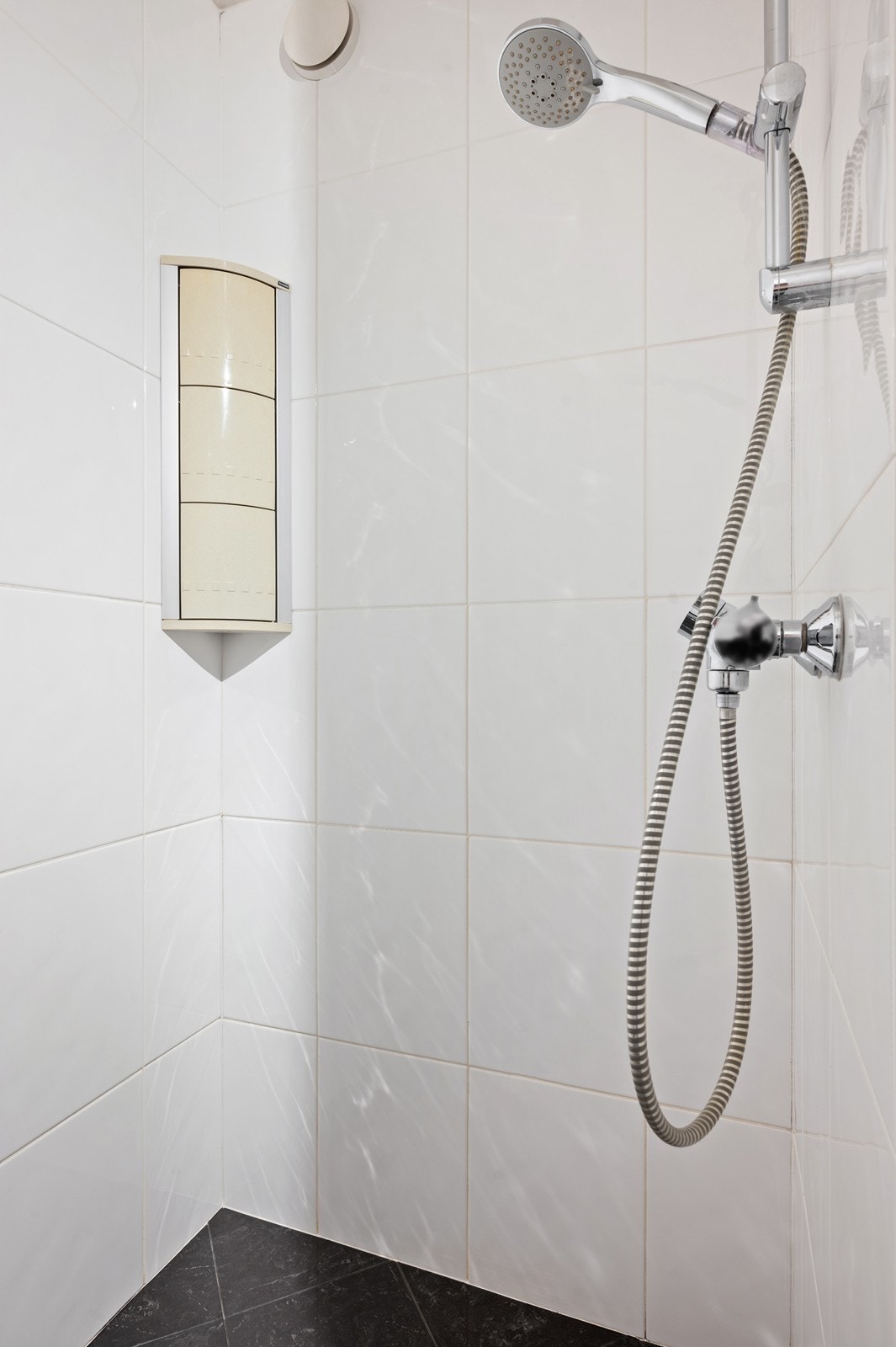 Rommet er innredet med nedfelt servant, veggmontert toalett og dusjvegger/hjørne. Galleribilde