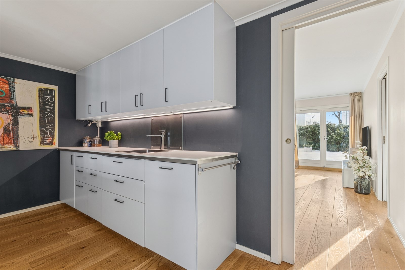 Kjøkkeninnredningen byr på god lagringsplass i både over- og underskap. Vaskekummen er nedfelt i en laminat benkeplate, og det er en kjøkkenvifte med stålhette og avtrekk ut i kanal. Galleribilde