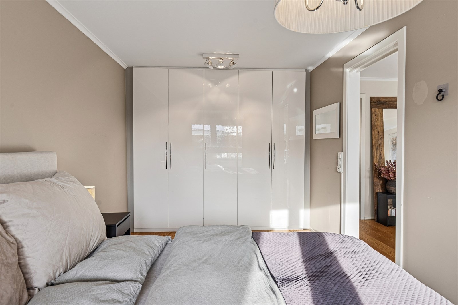 En stor garderobeløsning med glatte fronter gir rikelig med oppbevaringsplass. Galleribilde