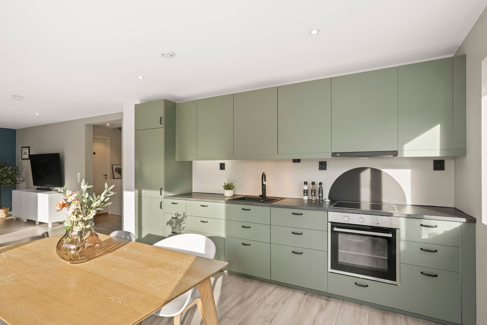 Kjøkkenet fremstår lekkert og moderne med slette fronter og benkeplater i laminat fra 2025. Galleribilde