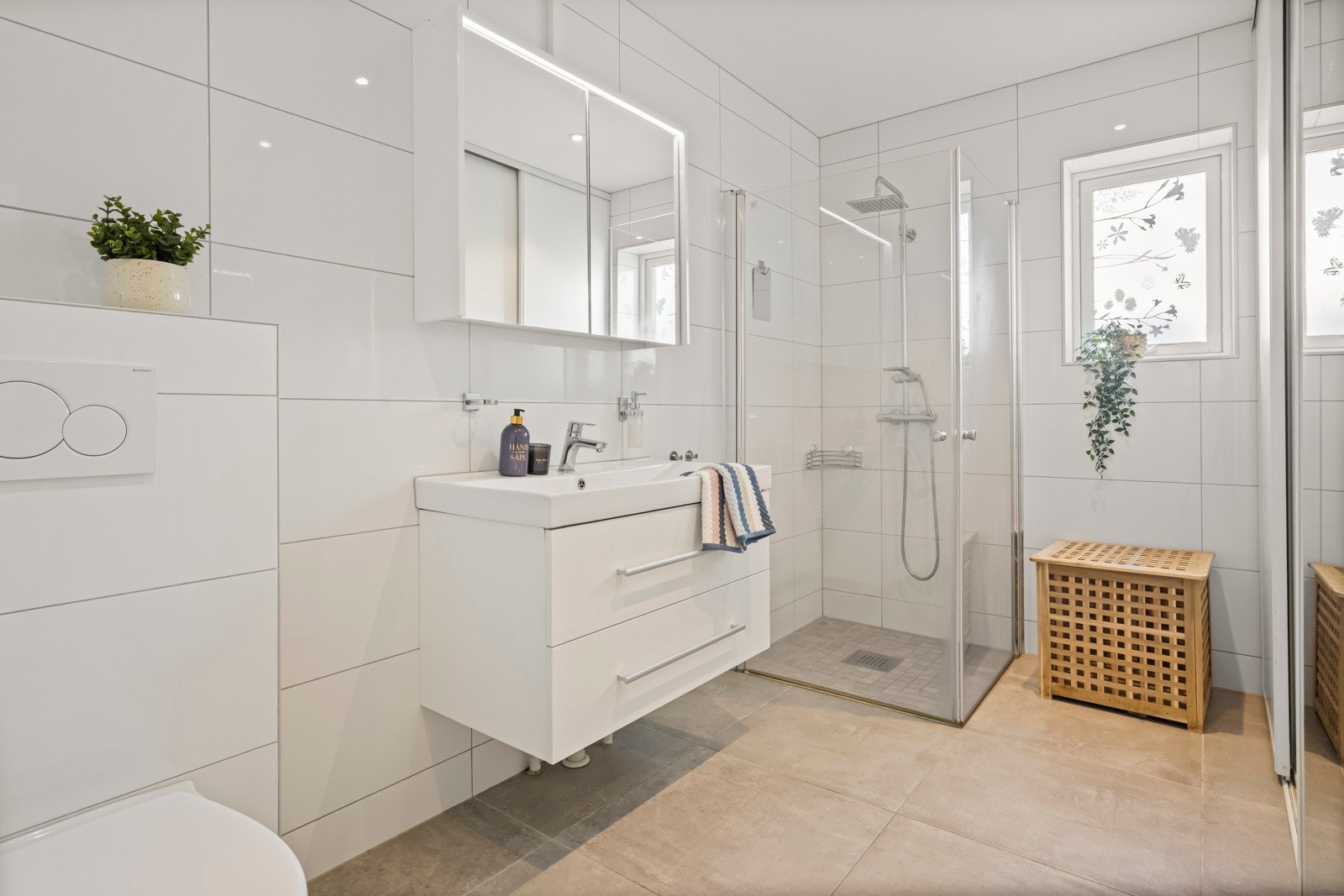 Badet i 1. etasje er pent flislagt og holder en moderne standard, med smarte skyvedører som skjuler vaskemaskin og tørketrommel - både praktisk og pent. Galleribilde