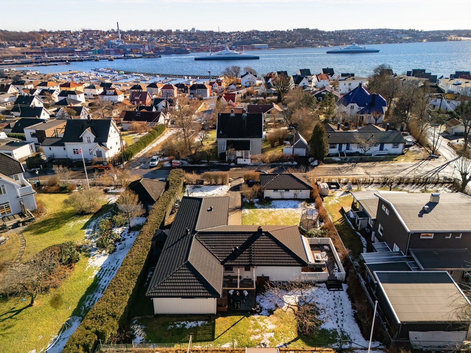 Tomten på 1 036 kvm er pent opparbeidet og innrammet av hekk, med plenarealer og variert beplantning. Galleribilde