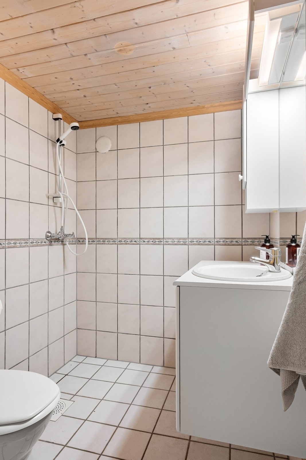 Bad 3 ligger i kjelleren. Rommet er flislagt og innredet med dusjhjørne, toalett og servantseksjon med skuffer samt speil og overskap. Selger opplyser at varmekablene ikke fungerer. Galleribilde