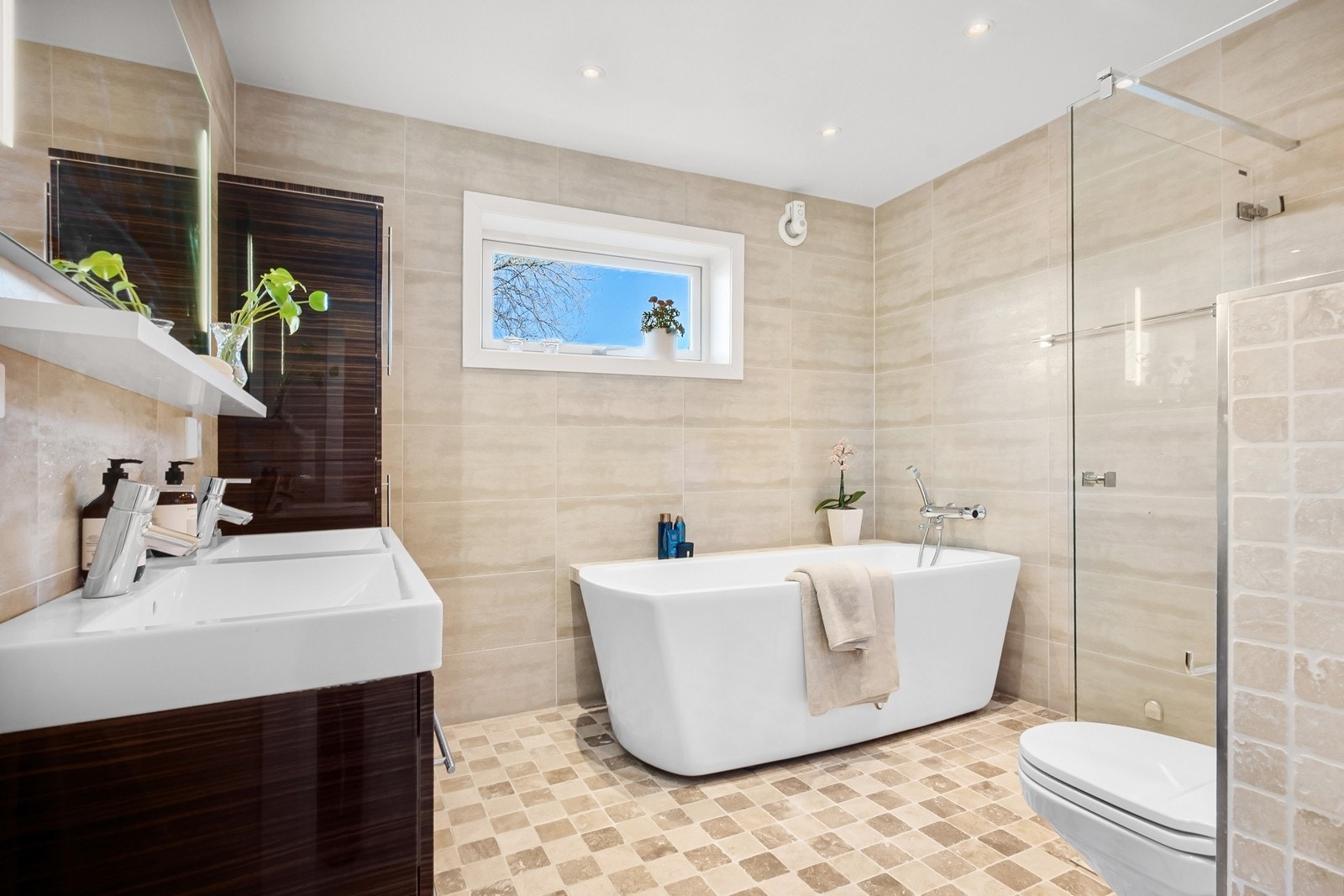 Bad 2 ligger i tilknytning til hovedsoverommet og har flislagte overflater, downlights og gulvvarme. Innredningen består av dobbel servantseksjon med skuffer, frittstående badekar og dusjhjørne. Galleribilde