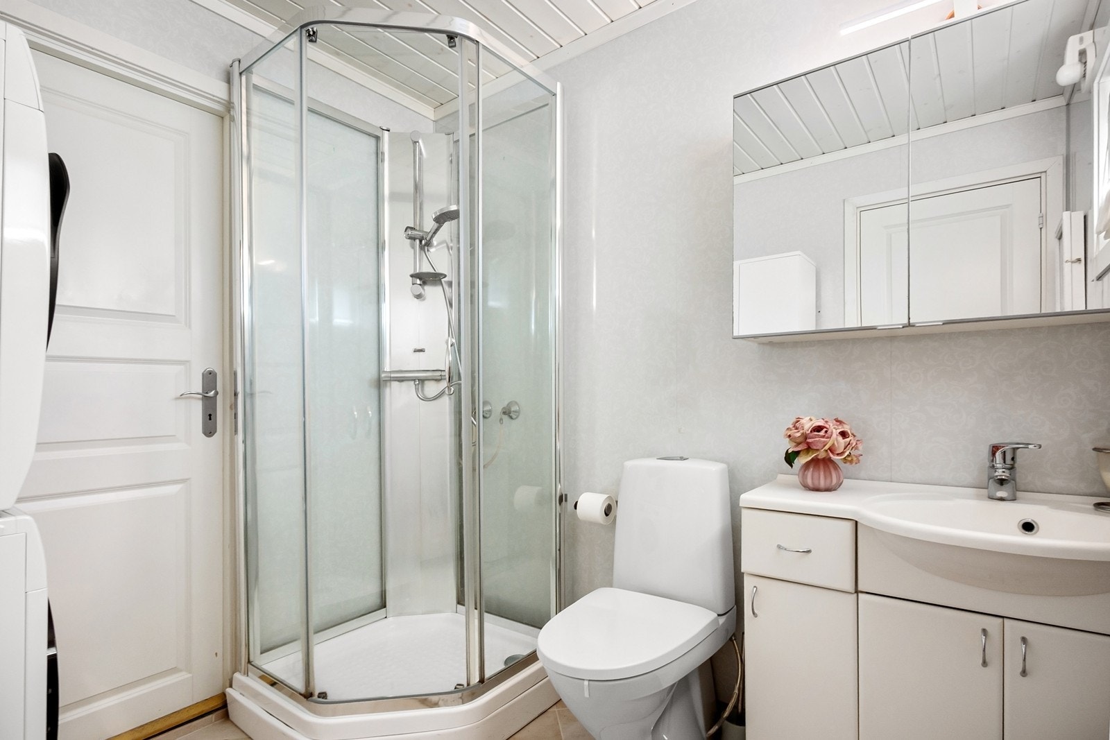 Badet har flislagt gulv med varmekabler. Rommet er innredet med servantseksjon med underskap, speilskap med oppbevaringsplass, toalett og dusjkabinett. Det er også opplegg for vaskemaskin. Galleribilde