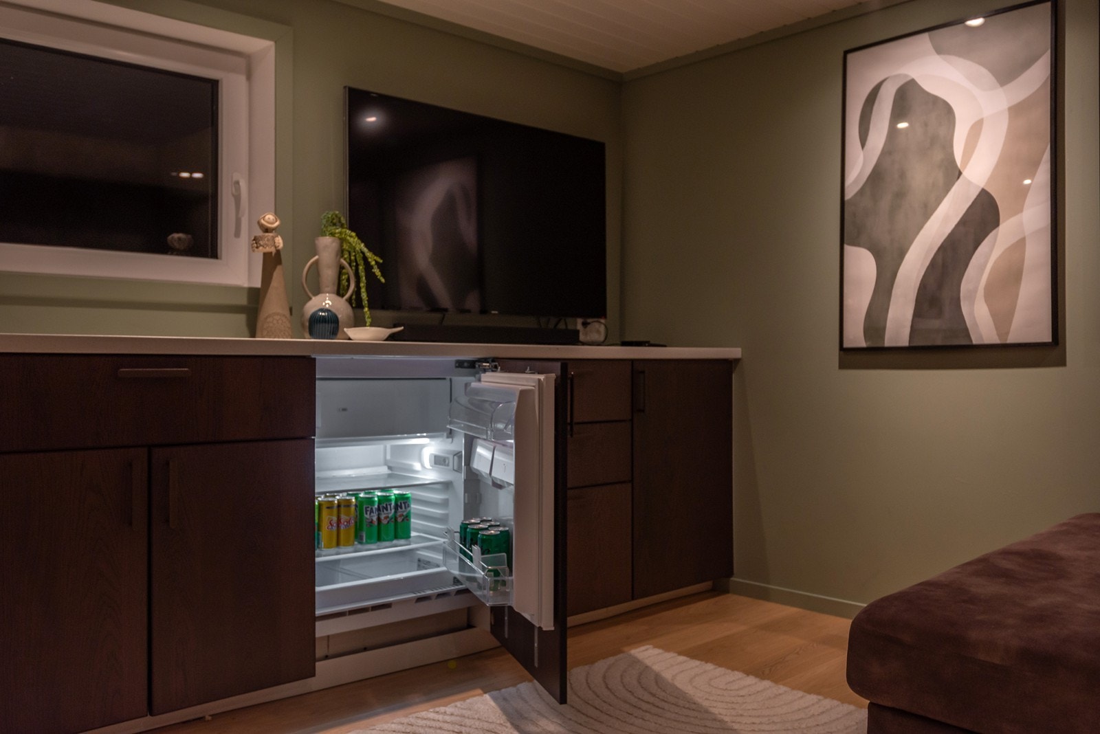 Langs den ene veggen er det lekker kjøkkeninnredning fra Ikea med integrert kjøleskap. Vinduene er også gravd ut og gir bedre lysforhold i rommet. Galleribilde