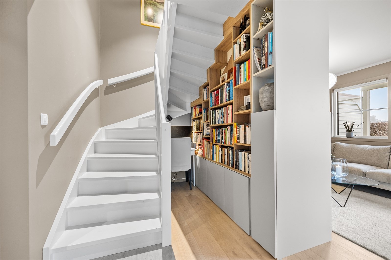 Hylleseksjonen i stuen er tosidig og gir et unikt preg - lite kontor er installert under trappen Galleribilde