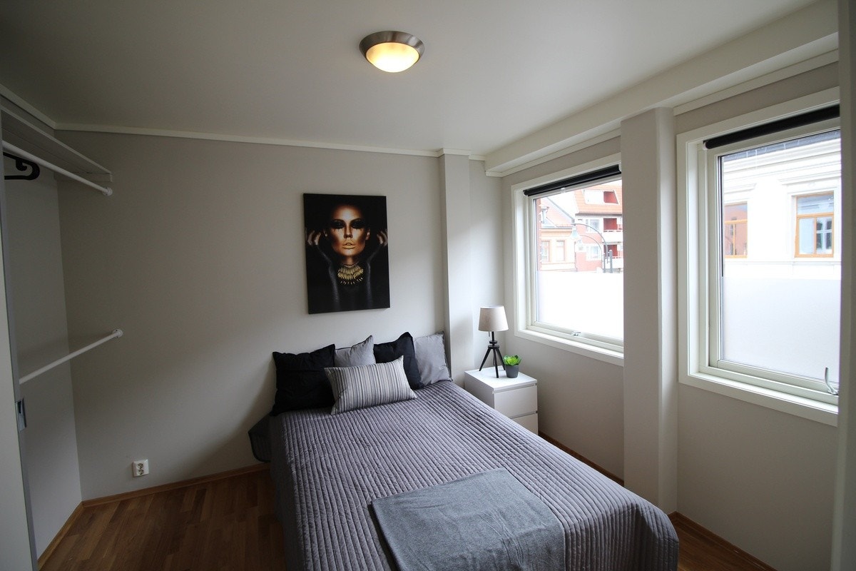 Soverom med 140cm seng, nattbord og to vinduer som gir mye lys Galleribilde