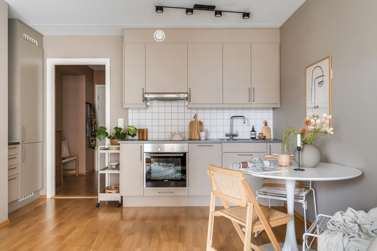 Praktisk og moderne kjøkken med innredning med slette fronter og gode oppbevaringsmuligheter. Laminat benkeplate med integrert oppvaskkum og ettgreps blandebatteri gir et stilrent og funksjonelt uttrykk Galleribilde