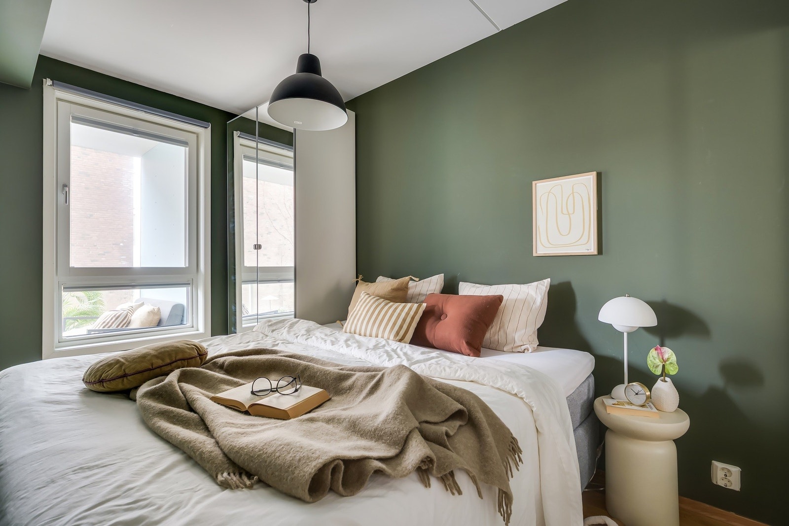 Lyst og romslig soverom med god plass til dobbeltseng og tilhørende møblement Galleribilde