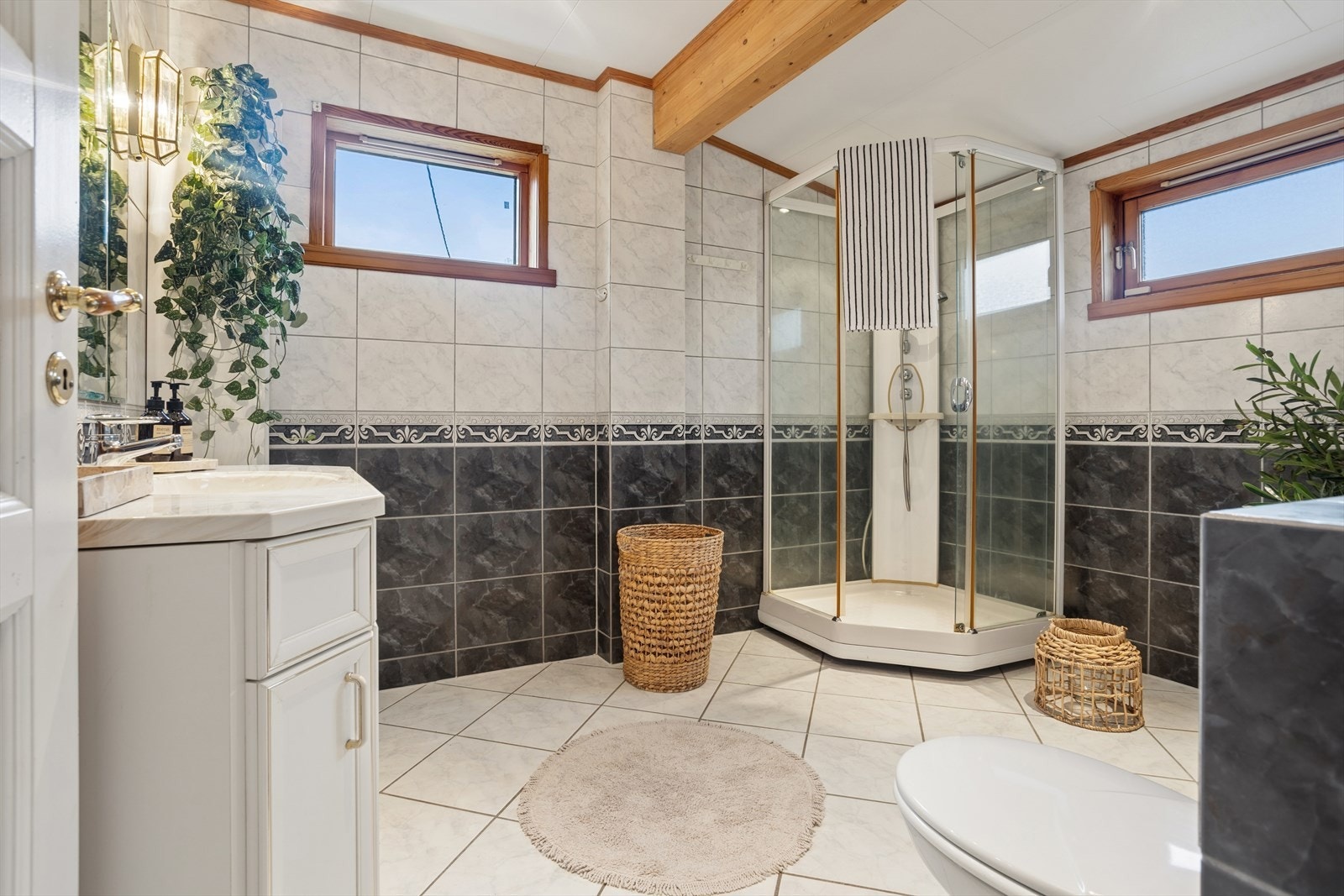 Badet har elektriske varmekabler i gulvet, dusjkabinett, vegghengt toalett og opplegg for vaskemaskin. Galleribilde