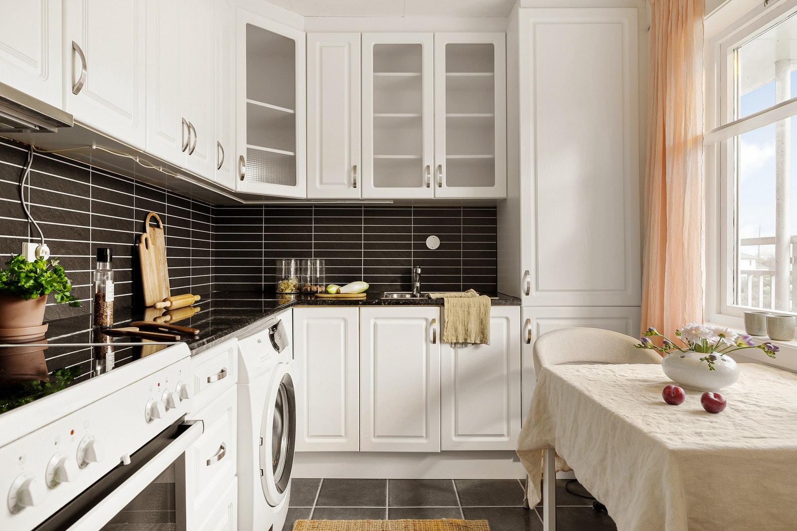 Kjøkkenet måler 6,3 kvm og er innredet med profilerte fronter, to glasskap og laminat benkeplate med nedfelt vask av stål. Galleribilde